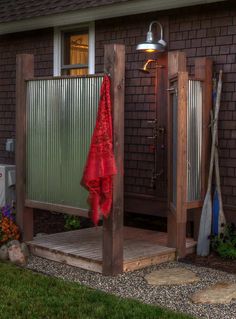 an outdoor shower in front of a brick house