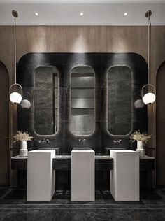 a bathroom with two sinks and three mirrors