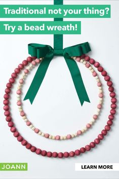 a green ribbon is attached to a bead necklace with pink and white beads on it