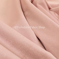 the fabric is soft and light pink with some slight folds on it's sides