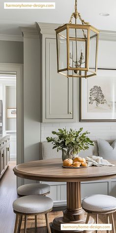 a dining room table with chairs and a potted plant in the center surrounded by white cabinets