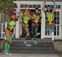 three women dressed in teenage mutant costumes are jumping up into the air with their arms outstretched