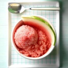 a watermelon sorbet in a white bowl with a spoon next to it