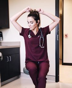 a woman with a stethoscope on her head sitting in a doctors office