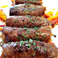 three steaks are on a plate with peppers and carrots