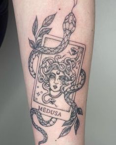 a woman's arm with a snake and medusa tattoo on the left thigh