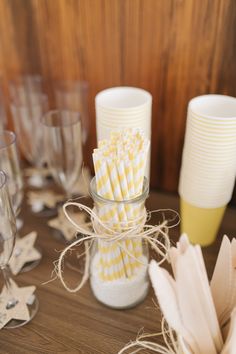 there are many different types of paper straws in the glass jars on the table