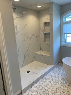 a bathroom with a tub, shower and shelves in the corner on the wall next to the bathtub