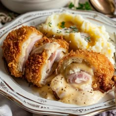 a white plate topped with meat covered in gravy and mashed potato wedges