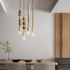 a dining room table with chairs and lights hanging from the ceiling