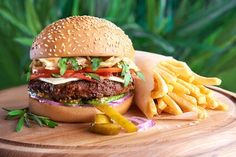 a hamburger and french fries on a wooden tray