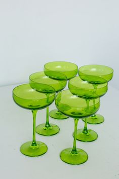 six green wine glasses sitting on top of each other