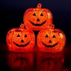 four glowing pumpkins sitting on top of a table