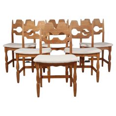 a set of six wooden dining chairs with upholstered back and seat cushions on each side