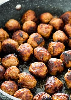 some meatballs are cooking in a skillet