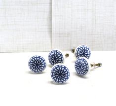 four blue and white ceramic knobs sitting next to each other on top of a table