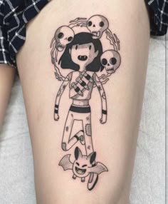 a woman's thigh with a cartoon character and skulls on her leg, as if she is holding an umbrella