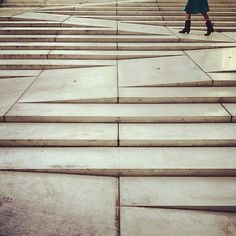 a woman is walking down some steps with an umbrella