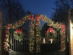 a gate decorated with christmas wreaths and lights