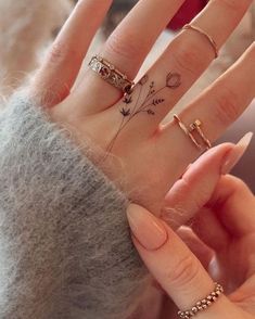 a woman's hand with four different rings on it