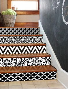 the stairs are painted with black and white designs on them, along with a basket full of flowers