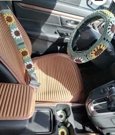 the interior of a car with sunflowers on the steering wheel cover and other accessories