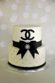 a white and black cake with a chanel logo on it