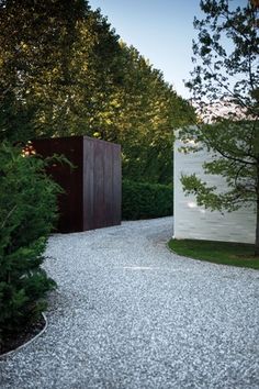 an outdoor area with gravel and trees in the background