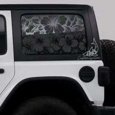 a white jeep with black flowers on it's side window and the words california