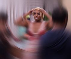 a blurry photo of a woman with her hands on her head