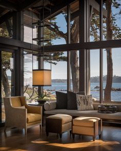 a living room filled with furniture next to a window covered in lots of large windows