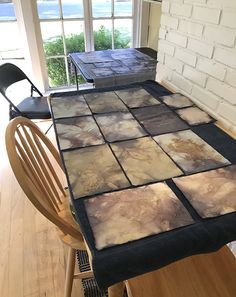 the table is made out of several different colored squares and has a black chair in front of it