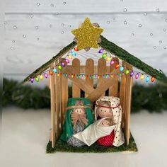 the nativity scene is displayed in front of a wooden fence with lights and decorations