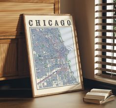 a map is sitting on a table next to a book and window with shutters