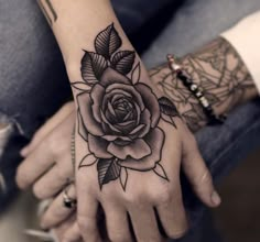 a woman's hand with a rose tattoo on it