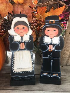 two small figurines made to look like they are dressed in pilgrim costumes and standing next to each other