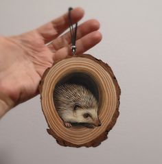 a hand holding a piece of wood with an animal inside it