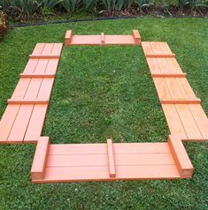 a wooden bench sitting on top of a lush green field with lots of grass around it