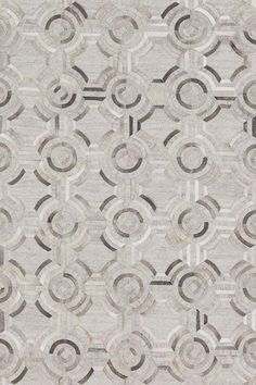 an area rug with circles on it in grey and beige colors, including the center circle