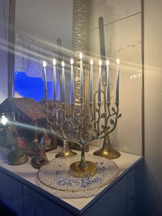 a lit menorah sitting on top of a table in front of a mirror