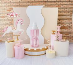 pink and white items are arranged in front of a brick wall with a horse on it