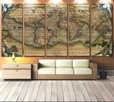 a living room with a couch and three large maps on the wall above it,