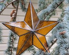 a stained glass star ornament hanging from a tree