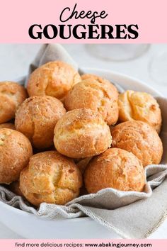 a white bowl filled with cheese gougeres on top of a pink and white table