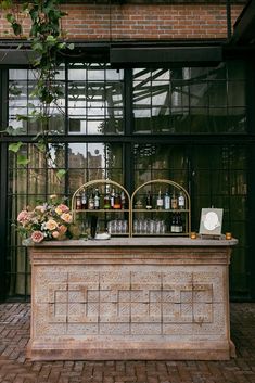 an outdoor bar with flowers and bottles on it