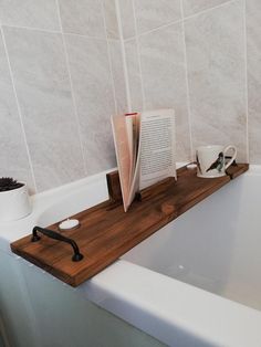 a bath tub with a book and cup on it