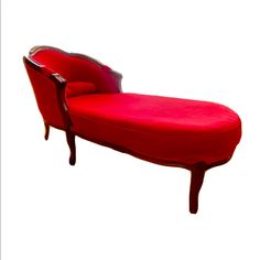 a red chaise lounge chair sitting on top of a white floor