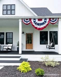 an american flag hanging on the front porch of a white house