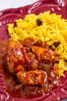 a red plate topped with rice and chicken