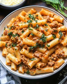 pasta with meat sauce and parsley in a white bowl